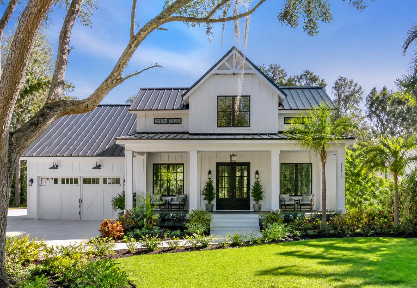Modern custom home with a metal roof and covered porch in a Florida neighborhood